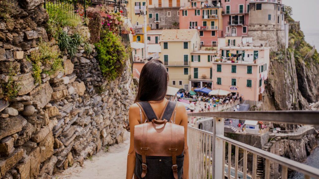 A young girl exploring the colorful streets of Riomaggiore, one of the picturesque villages in Cinque Terre, Italy.